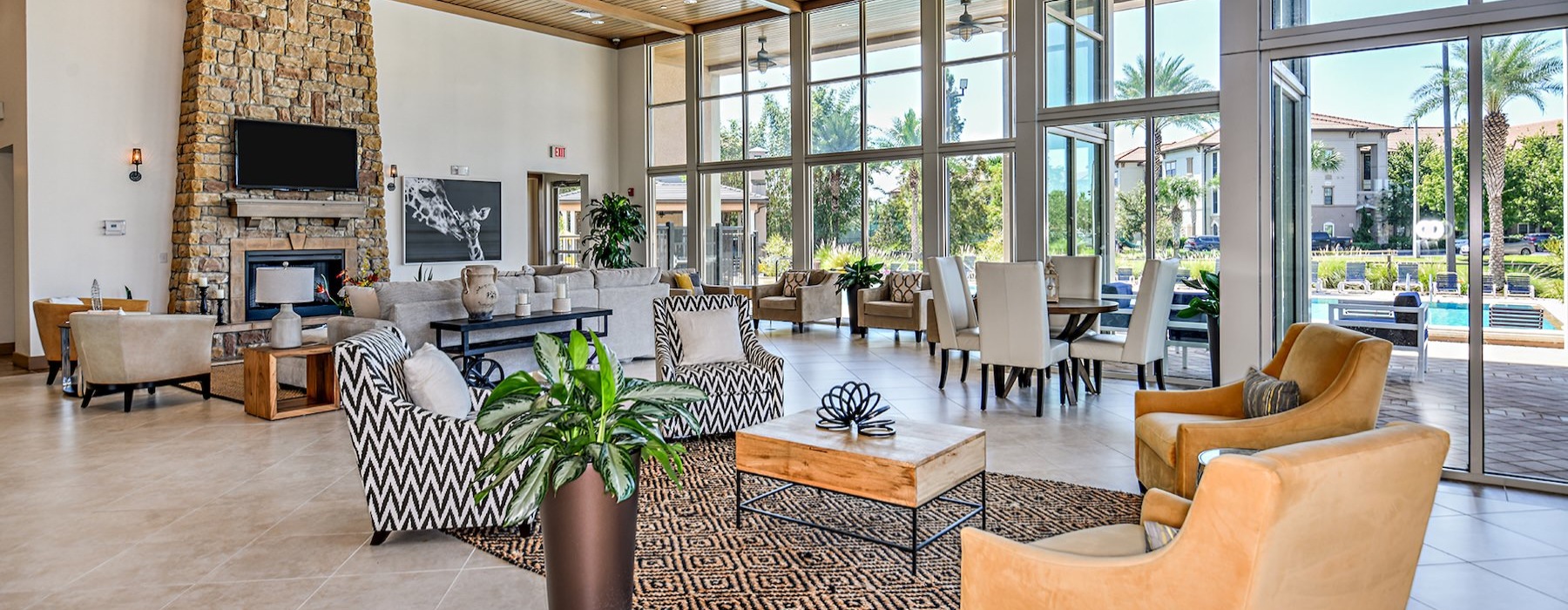 clubhouse with seating tables large windows and tv