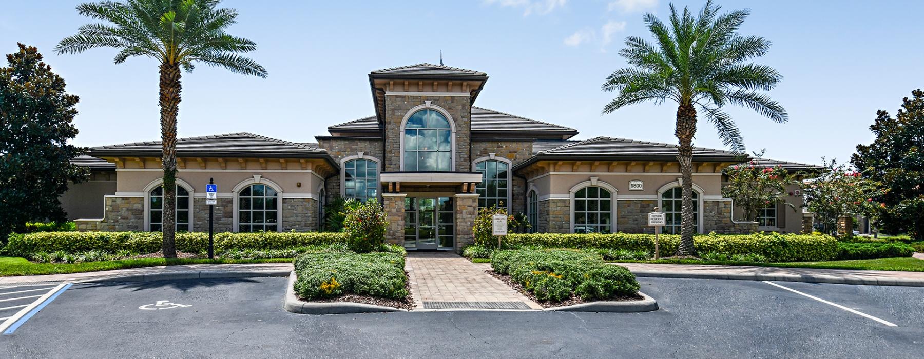 a building with palm trees and bushes